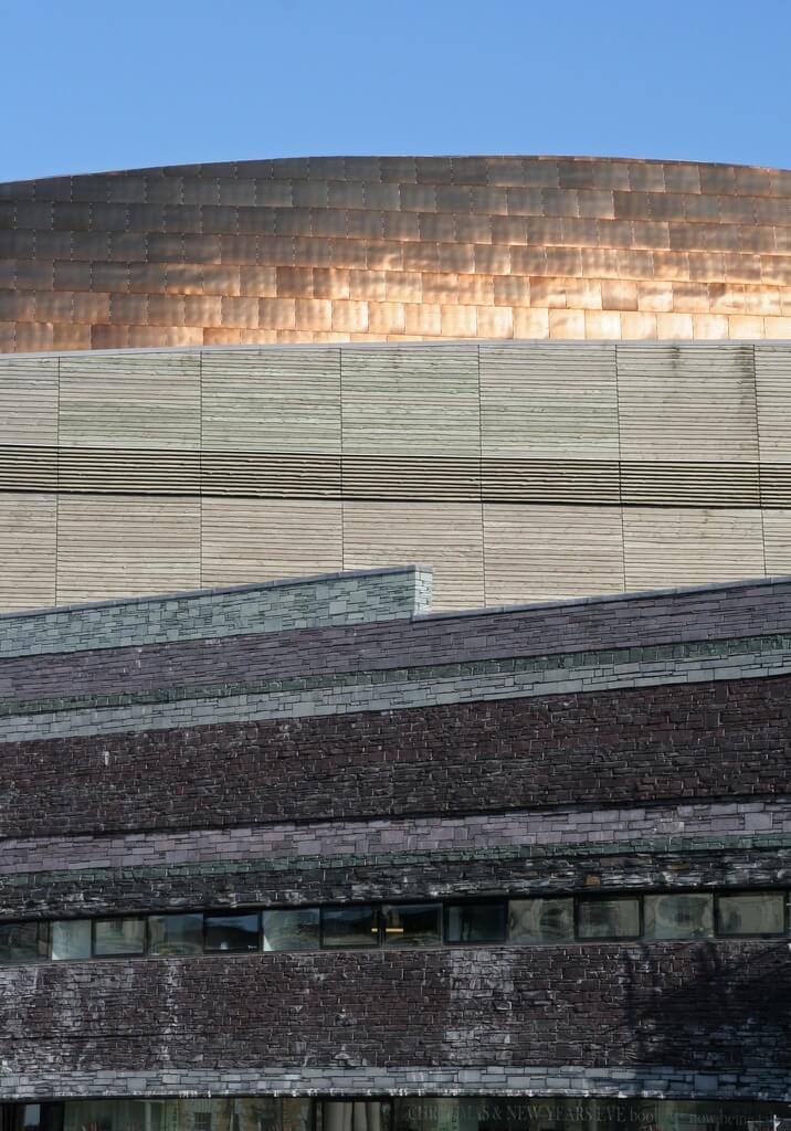 College Station roofer shows Millennium Centre with copper, metal, slate, and wood roofing.