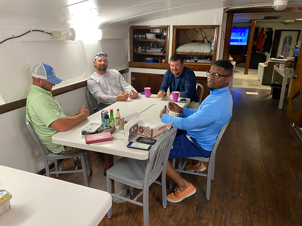 Schulte Roofing team plays dominoes on ship