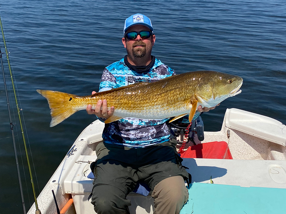 Josh Schulte catches fish on Schulte Roofing company trip