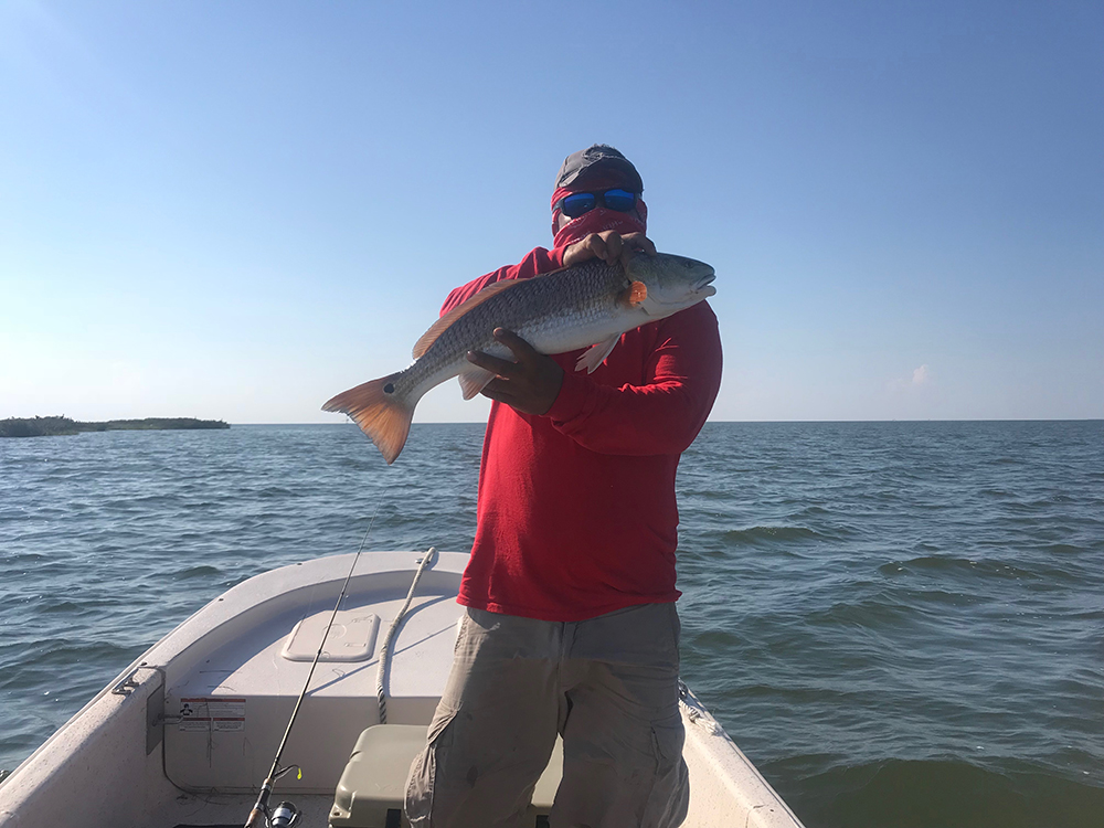 Employee catches redfish on Schulte Roofing company trip