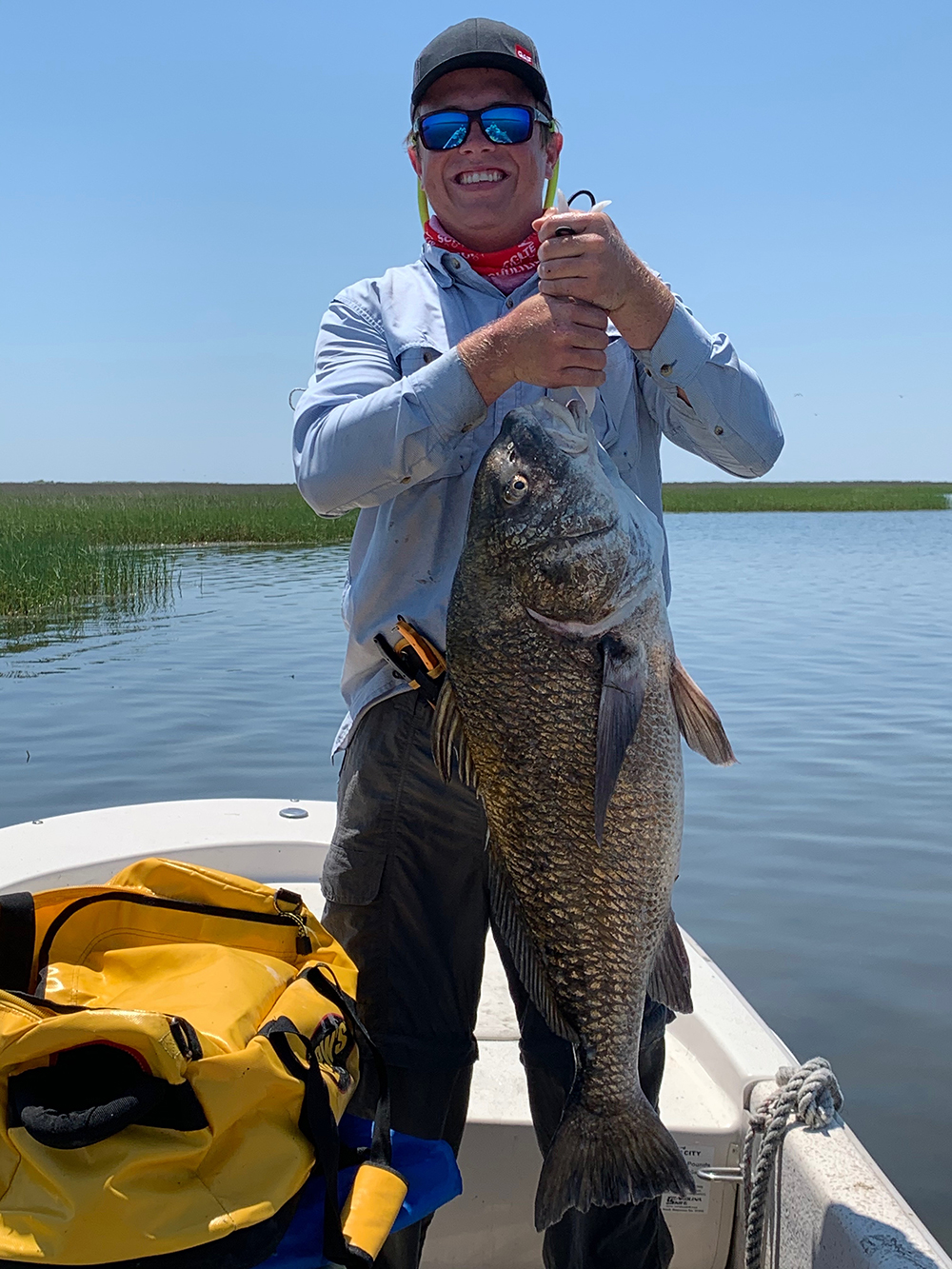 Regan catches a giant black drum fish on the company fishing trip