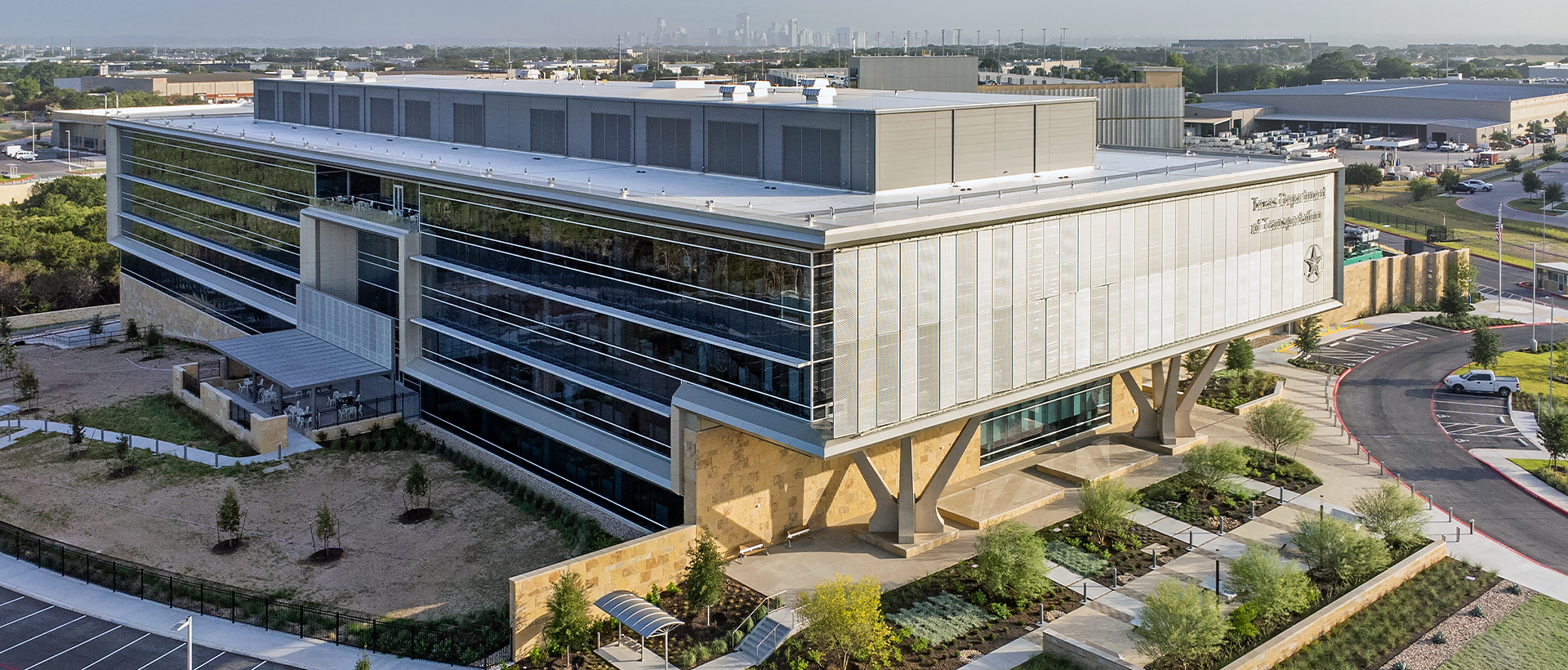 Texas Department of Public Safety-Schulte Roofing Texas Department of Public Safety's finished commercial flat roof by Schulte Roofing and building facade with view of the entire building and Austin skyline.