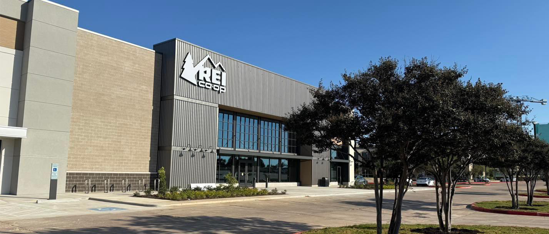 REI Commercial Roofing - Schulte Roofing REI building facade with finished landscaping and entrance into the store. Commercial roof finished by Schulte Roofing.